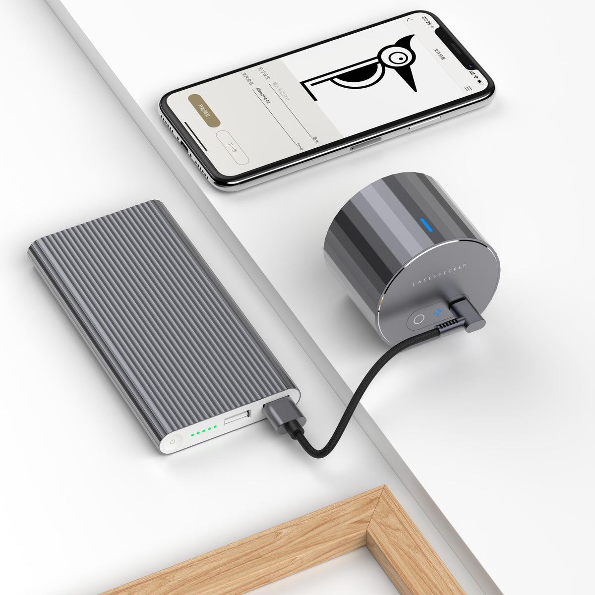LaserPecker portable cylindrical engraver LP1 Pro, powered by an external power bank for untethered use, paired with a smartphone app for design editing, enabling on-the-go creative engraving anywhere.