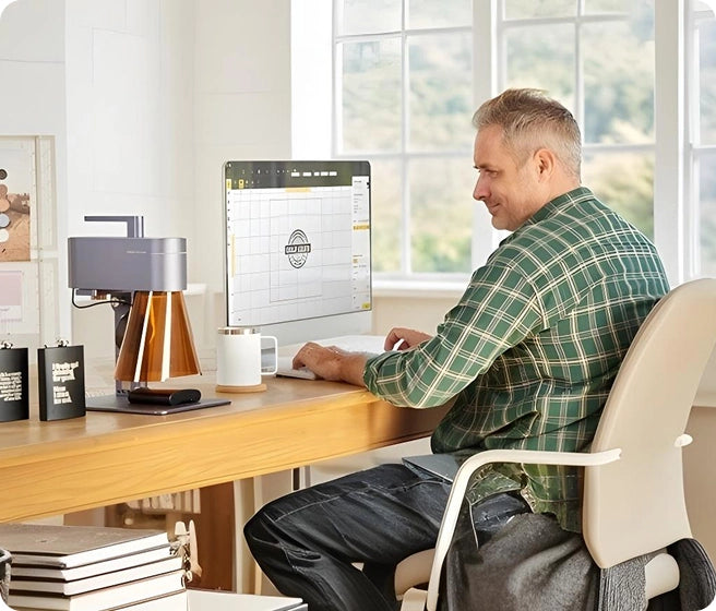 A creator utilizing LaserPecker Design Space LDS software on a desktop PC to edit graphics for laser engraving.
