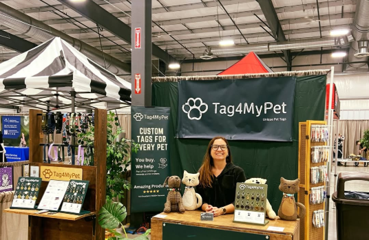 Tag4MyPet pet business booth at a market – Real User Story scene showing custom pet tag display, plush pets, and vendor; highlights LaserPecker LP5's excellent engraving quality, easy operation, and on-site personalization that customers love.
