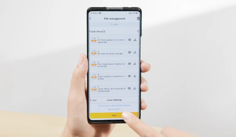 Hand holding a smartphone displaying LaserPecker LP5's mobile app interface (for file & offline job management), showcasing the flexible connectivity (Wi-Fi/wired connection) that boosts workflow convenience.