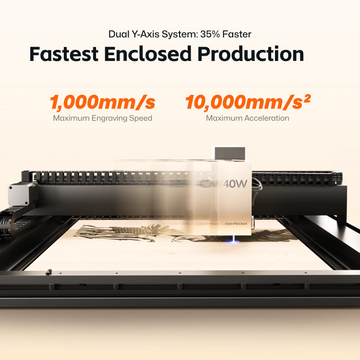 LaserPecker enclosed desktop laser cutter LX2 in action, highlighting its dual Y-axis system for 35% faster production. The machine achieves a maximum engraving speed of 1,000mm/s and maximum acceleration of 10,000mm/s², with a 40W laser head engraving a detailed design on a wooden sheet. 