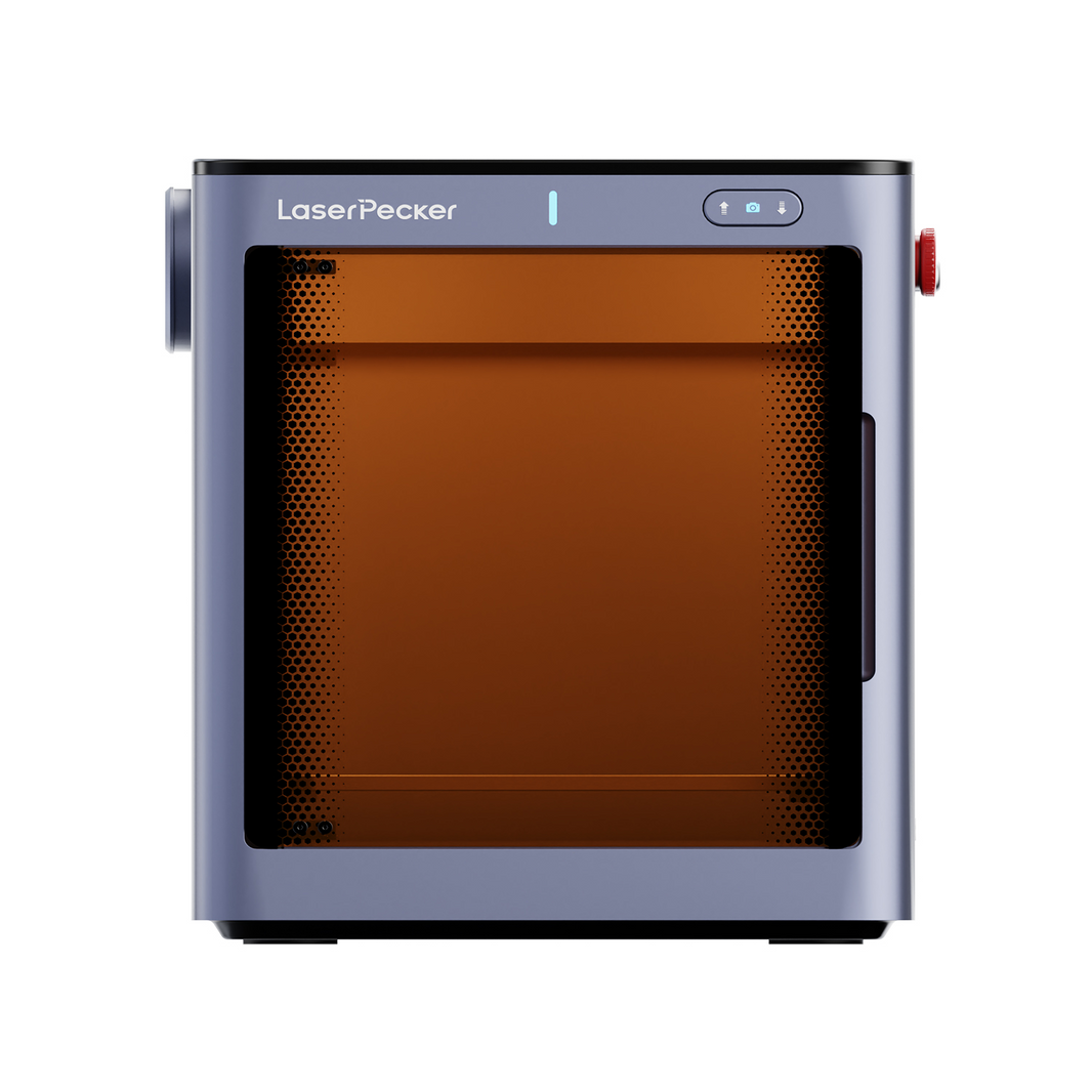 Front view of the LaserPecker enclosed laser engraver, featuring a safety-tinted orange viewing window with a perforated metal frame, emergency stop button, and status indicator lights. The compact, cube-shaped design emphasizes safety and space efficiency for desktop use.