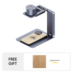 LaserPecker portable engraver mounted on a foldable desktop stand, engraving a "Mountain" design onto a wooden phone case, bundled with a free 3-piece materials kit for immediate use.