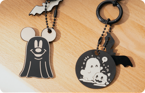 Two engraved wooden keychains featuring Halloween designs.