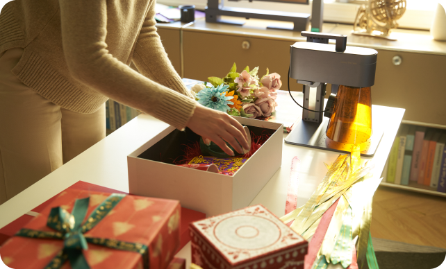 A woman packing various engraved products into a gift box.