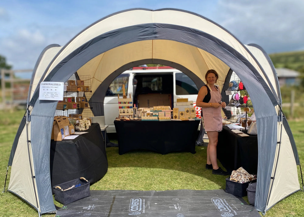 A booth showcasing handmade and engraved items, with the seller beside the display.