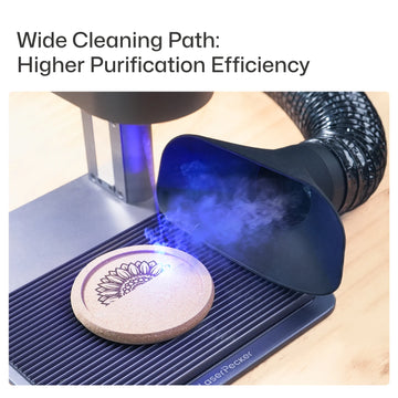 Dust Hood Collector in use with a LaserPecker laser engraver, efficiently capturing smoke and debris from the engraving of a sunflower design on a cork coaster, demonstrating its wide cleaning path and high purification efficiency.
