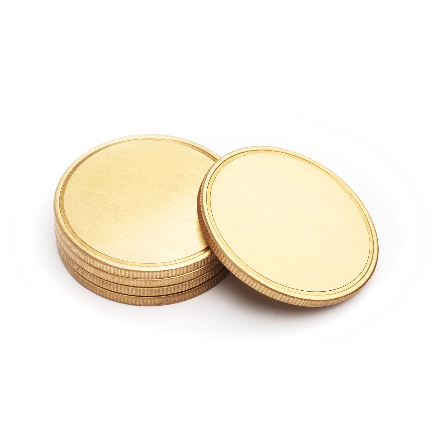 Stack of blank, gold-colored metal coins with a brushed finish and reeded edges, presented as ideal materials for laser engraving custom commemorative tokens, challenge coins, or personalized gifts, against a clean white background.