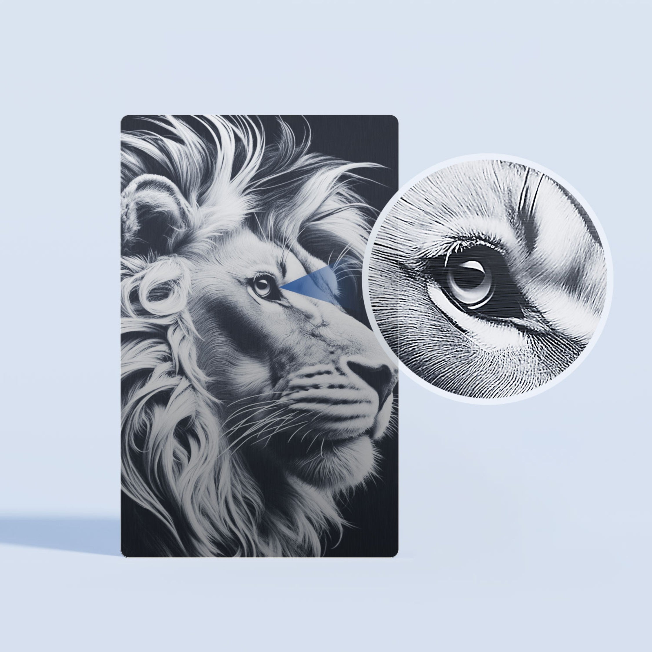 A highly detailed laser-engraved lion portrait on a black metal card, with a close-up inset highlighting the intricate texture of the lion's eye, showcasing the high-precision engraving quality achievable on blank metal card blanks.
