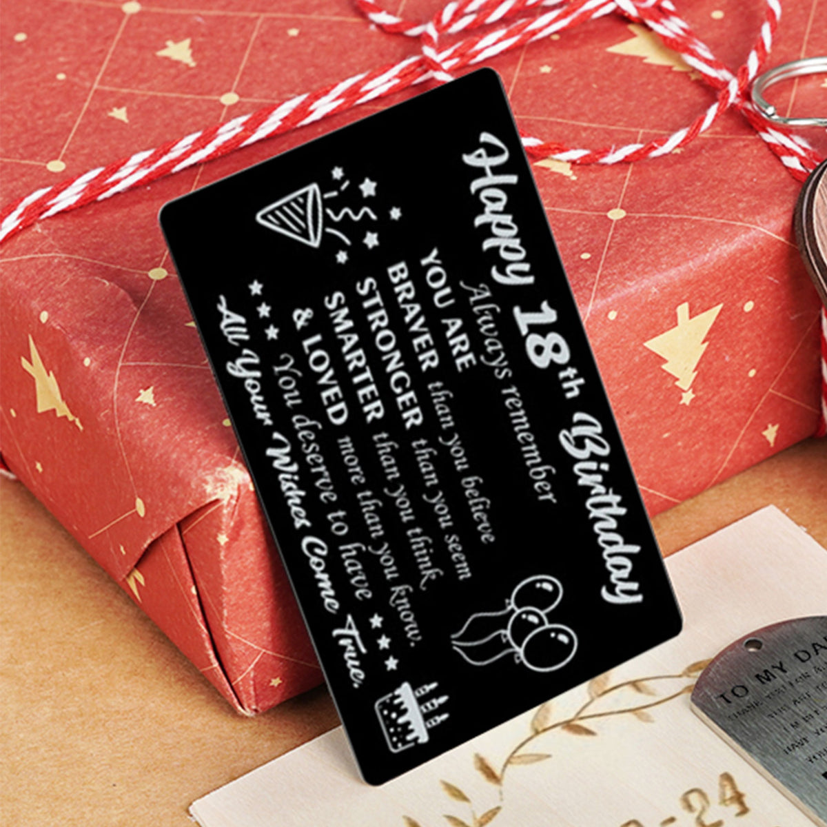 A laser-engraved black metal 18th birthday greeting card, featuring a heartfelt message: "Happy 18th Birthday", "Always remember YOU ARE BRAVER than you believe, STRONGER than you seem, SMARTER than you think, & LOVED more than you know. You deserve to have All your Wishes Come True", paired with playful doodles like a party hat, mouse, and cake, presented as a durable, personalized keepsake gift.
