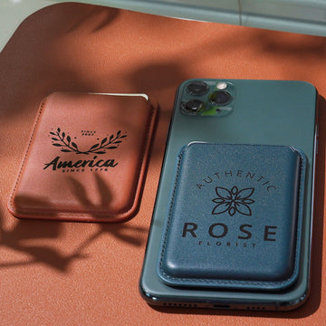 This image features two laser-engraved faux leather card holders, designed to highlight personalization and branding potential. The brown holder displays a botanical wreath logo with the text “America SINCE 1776”, while the teal version, attached to a smartphone, features a floral emblem and the branding “AUTHENTIC ROSE FLORIST”. Both pieces showcase how crisp, permanent laser engraving can turn slim, functional accessories into stylish, branded gifts or everyday essentials.
