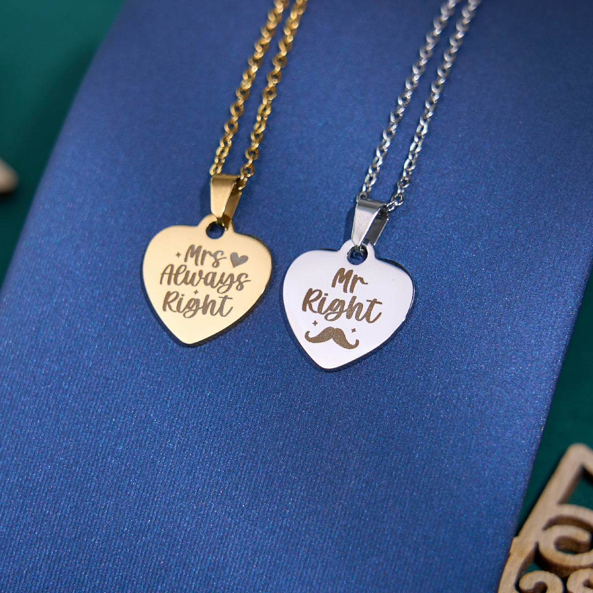 A pair of playful, personalized heart-shaped pendant necklaces designed as a couples’ set: the gold pendant is engraved with “Mrs Always Right” alongside a tiny heart, while the silver pendant reads “Mr Right” with a whimsical mustache detail. Presented on a rich blue display, these laser-engraved pieces make a lighthearted, romantic gift for anniversaries, weddings, or Valentine’s Day, blending humor with sentimental personalization.
