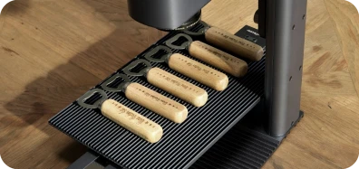 LP2 Plus slide extension batch engraves wooden bottle openers for custom gifts and promotional items.